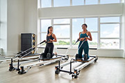 Two women on the pilates machines